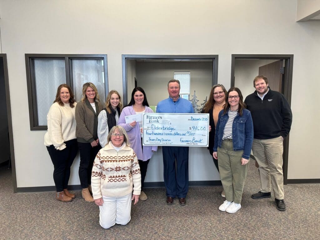 Group holding oversized donation check in office